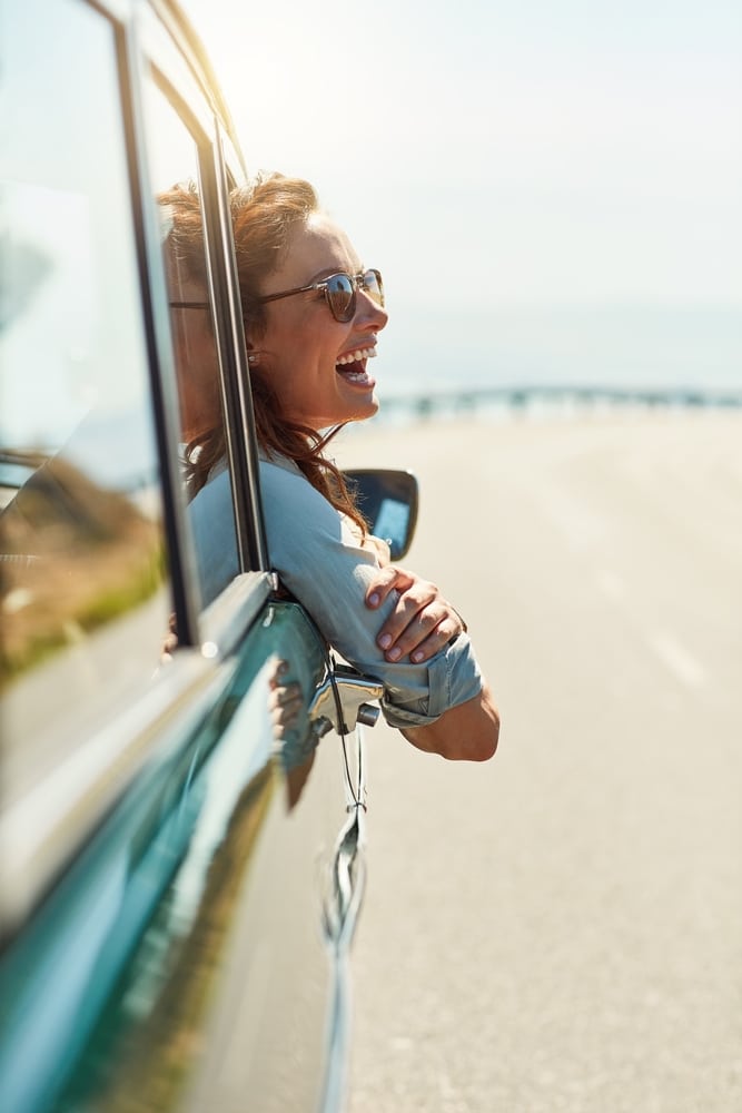 A woman enjoys life with a confident laugh and beautiful smile from All Valley Dental