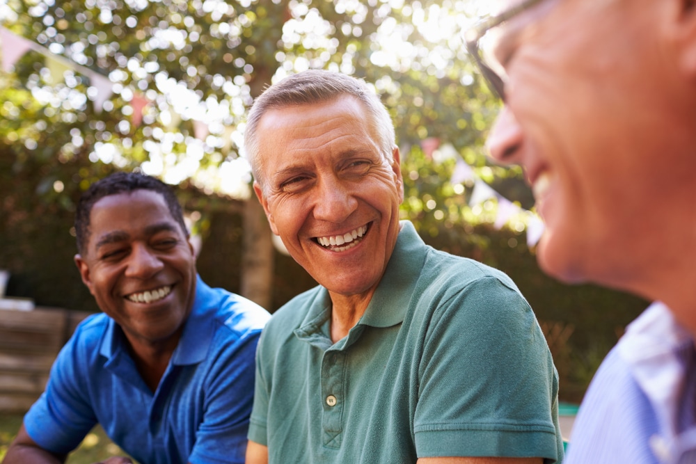 A group of friends laughing, their smiles are bright thanks to Oral Hygiene Aids at All Valley Dental